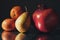 Classic still life image of mandarin, pear and pomegranate on a metal reflective surface. Dark background. Selective focus