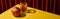 Classic still life with pomegranate near glass of red wine on yellow table near red curtain, panoramic shot