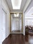 Classic style hall with white walls and built-in sliding wardrobe with golden frame