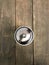 A CLASSIC SUGAR DISPENSER WITH A METAL TOP SITS ATOP A WOODEN TABLE