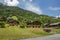 Classic swiss chalet in the middle of green alpine meadows . Cozy rural village Champery in Switzerland. Bright blue sky and white