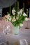 Classic table setting. White tablecloth.Vase with hydrogel and white flowers