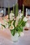 Classic table setting. White tablecloth.Vase with hydrogel and white flowers