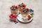 Classic tiramisu dessert with blueberries and raspberries in a glass and bowls with berries on concrete background