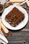 Classic tiramisu dessert on ceramic plate and savoiardi cookies on wooden background