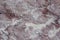 Classic travertine texture. Reddish-brown base with dark and gray spots. Used as a background.