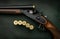 Classic trigger double-barreled hunting rifle on a green background. Smooth-bore hunting rifle open for reloading. Concept
