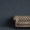 Classic tufted sofa in gray empty room with relief stripe wall