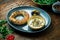 Classic Turkish breakfast - simit with feta cheese mousse with olive oil and spices, served on blue plate with olives. Wood