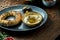 Classic Turkish breakfast - simit with feta cheese mousse with olive oil and spices, served on blue plate with olives. Wood