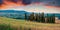 Classic Tuscan view with cypress trees on the field of wheat. Colorful summer sunrise in Italian countryside. Traveling concept