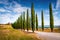 Classic Tuscan view with farmhouse and cypress trees. Colorful summer view of Italian countryside, Val d`Orcia valley, San Quiric