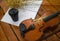 The classic violin and bow put on wooden timber ground floor,beside mobile phone and black coffee cup