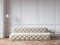 Classic white interior with capitone chester sofa, mouldings, wooden floor, floor lamp