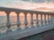 Classic white plaster balustrade on the background of a calm sea at sunset - a delicate pink mood