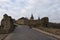 Classic wide-angle landscape view of cobble stone road to the ancient Kamianets-Podilskyi Castle against cloudy winter sky.