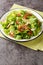 Classic Wilted Lettuce Salad With Bacon Dressing closeup in the plate. Vertical