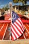 Classic wooden speed boat with nautical flag docked in front of a house on the lake - view from back with flag in focus