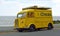 Classic yellow Citroen Hy Van with Service Citroen logo on the side parked on seafront promenade.