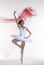 Classical Ballet Ideas. Professional Japanese Female Ballet Dancer Posing in White Tutu With Flying Red Cloth In Hands Against