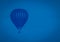 Classical blue colored hot-air balloon flying in the sky, toned