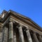 Classical building portico facade columns blue sky looking up