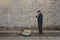 Classical busker standing against a brick wall