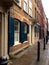 Classical european building in english manner with shutters on town street after rain.