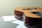 Classical guitar and music sheets on gray textured table