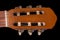 Classical headstock of acoustic guitar close-up on black background