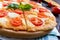 Classical Italian pizza `Margarita` with mozzarella, tomatoes, basil