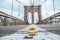 Classical yellow taxi model on an empty Brooklyn Bridge during lockdown in New York, because of the pandemic