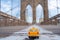 Classical yellow taxi model on an empty Brooklyn Bridge during lockdown in New York, because of the pandemic