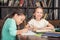 Classmates doing homework together in library