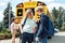 Classmates going to school by bus boy holding friend`s shoulder talking supporting close-up