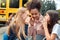 Classmates going to school by bus girls standing close-up gossip smiling playful