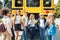 Classmates going to school standing near bus talking happy