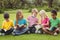 Classmates sitting in grass and reading books