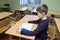 Classroom of the medrese. Muslim boy sitting at a school desk, Quran placed in front of him