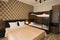 Classy hotel bedroom interior design. Large bed, bunk-beds. Family room with brown color tone furniture