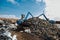 Claw crane grabbing the scrap at a rubbish dump