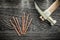 Claw hammer brass nails on wooden board top view