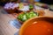 Clay bowls of chopped vegetables and delicious traditional Mexican pozole