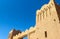 clay brick gate of old african kasbah castle against blue sky