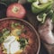 Clay brown plate and spoon with red borsch with sour cream on a