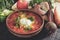 Clay brown plate and spoon with red borsch with sour cream on a