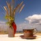 A clay ceramic vase and a cup with a saucer placed on a linen tablecloth on the sea beach...The lower parts of the vase and mug
