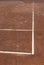 Clay cort tennis game white lines corners contrasting to orange