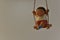 Clay dolls, cute chubby children playing on the swing, are hanging in a high place.