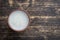 Clay glass of banana milkshake on wooden background. Top view, copy space